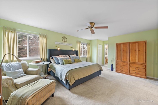 carpeted bedroom with ceiling fan and ensuite bath