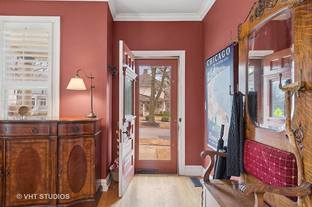 foyer featuring visible vents, crown molding, baseboards, and wood finished floors