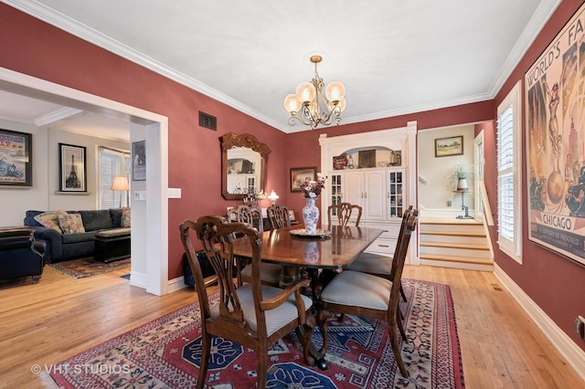 dining space with visible vents, crown molding, and light wood-type flooring