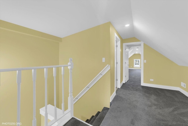 hallway featuring lofted ceiling, recessed lighting, an upstairs landing, baseboards, and dark carpet