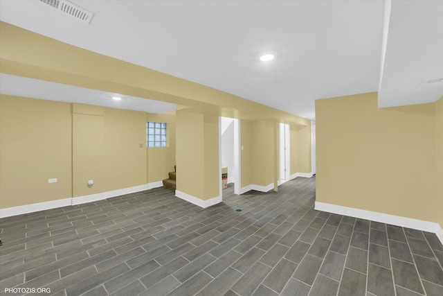 basement with recessed lighting, stairway, and baseboards