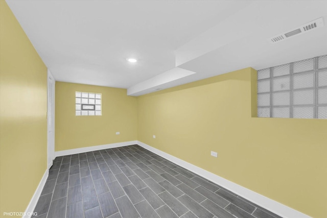 basement with recessed lighting, dark wood finished floors, visible vents, and baseboards