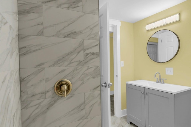 bathroom featuring marble finish floor, walk in shower, and vanity