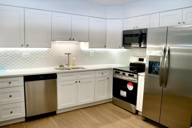 kitchen featuring light wood-type flooring, appliances with stainless steel finishes, sink, and white cabinets