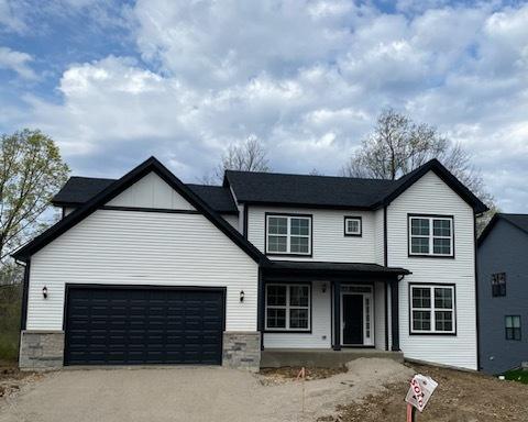 view of front of property with driveway, covered porch, and a garage