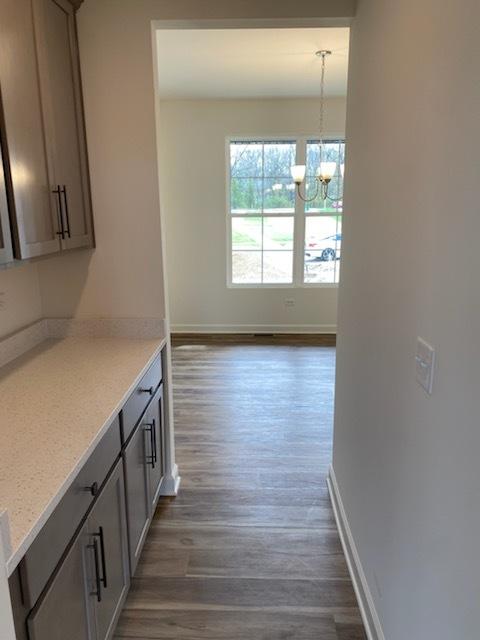 interior space featuring dark wood finished floors, baseboards, and a notable chandelier