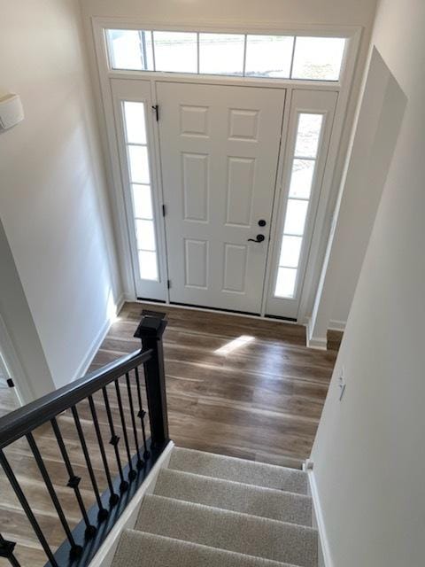 entrance foyer featuring stairway, baseboards, and wood finished floors
