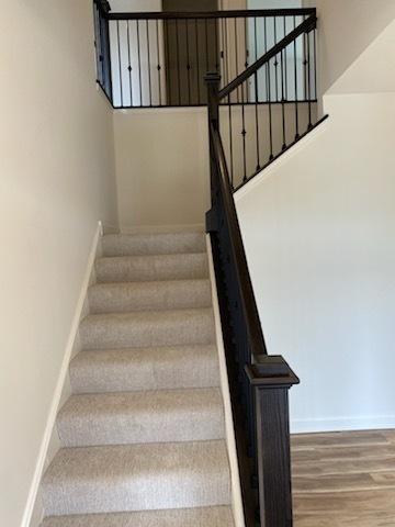 stairway featuring baseboards and wood finished floors
