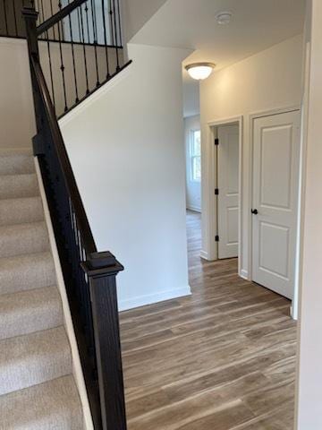 staircase with baseboards and wood finished floors