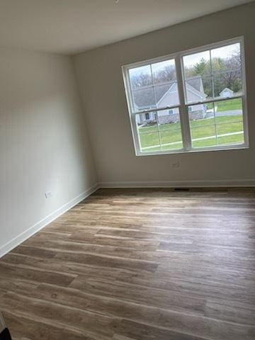 empty room with dark wood finished floors and baseboards