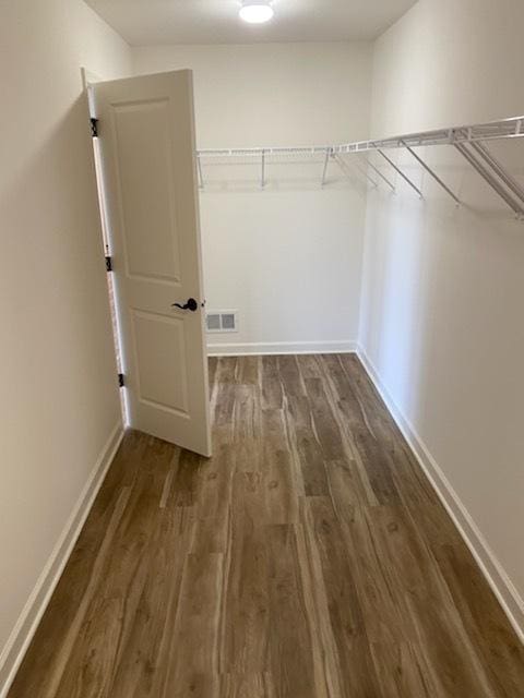 spacious closet featuring wood finished floors and visible vents