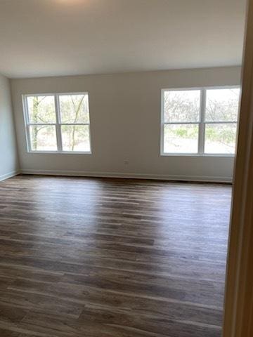 empty room featuring dark wood finished floors and baseboards