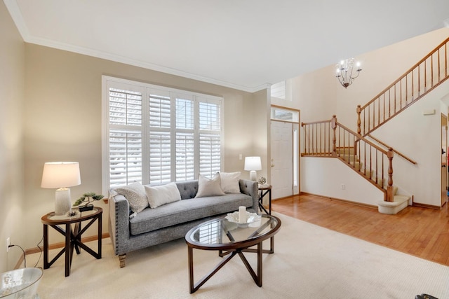 living room with an inviting chandelier, crown molding, and light wood-type flooring