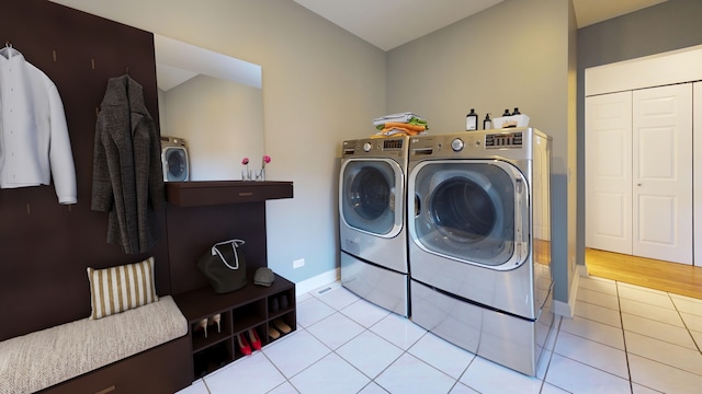 clothes washing area featuring washer and dryer and light tile patterned floors