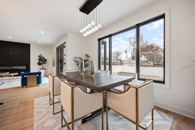 dining room with recessed lighting, baseboards, and light wood finished floors