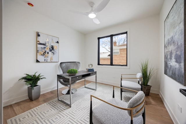 home office featuring a ceiling fan, baseboards, and wood finished floors