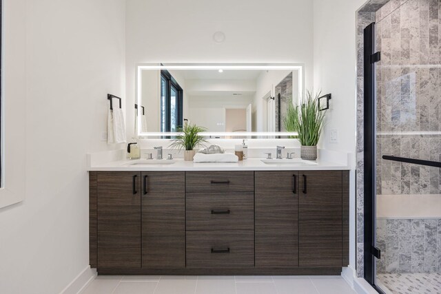 bathroom featuring double vanity, a stall shower, tile patterned flooring, and a sink