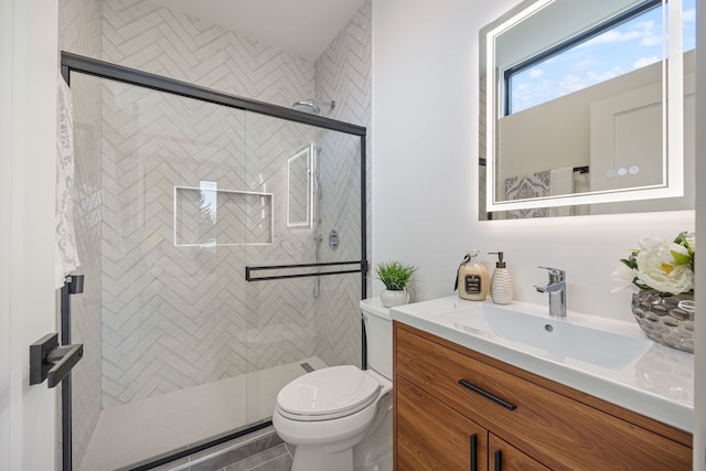 bathroom with a shower stall, toilet, and vanity