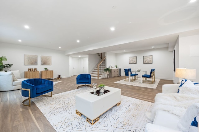 living area with stairs, baseboards, wood finished floors, and recessed lighting