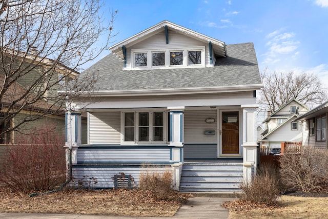 bungalow featuring a porch and roof with shingles