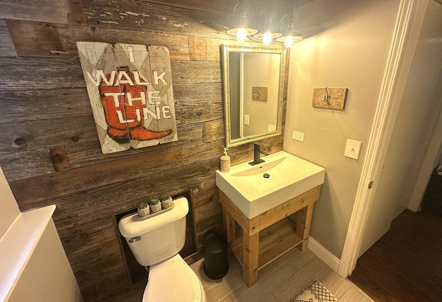 bathroom with wood-type flooring, toilet, and sink