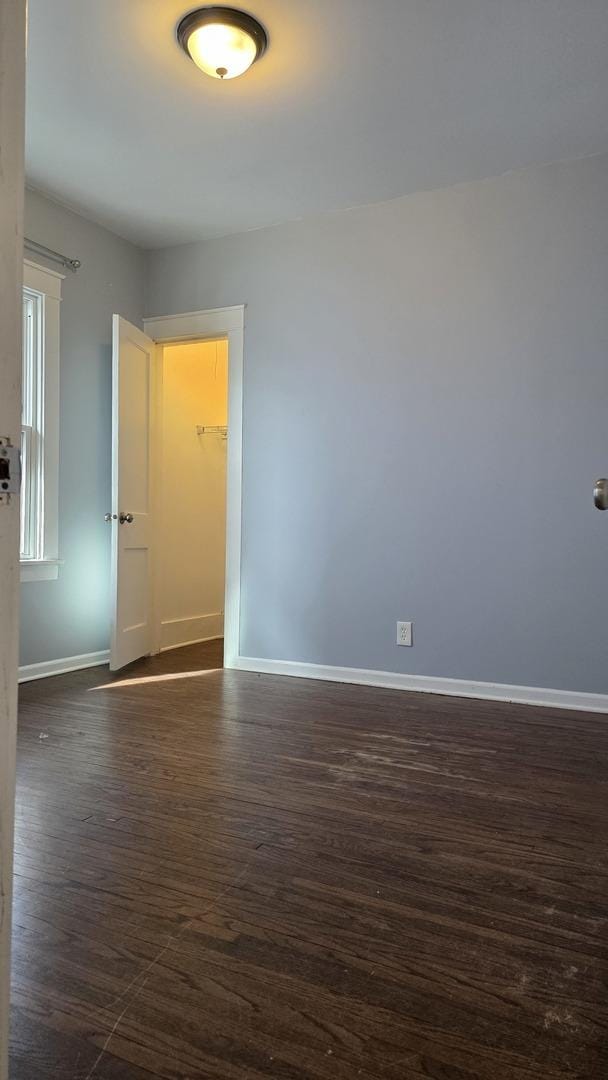 unfurnished room featuring dark wood-type flooring