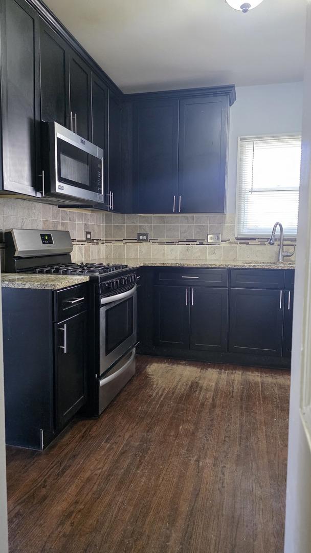 kitchen featuring sink, decorative backsplash, stainless steel appliances, and dark hardwood / wood-style floors