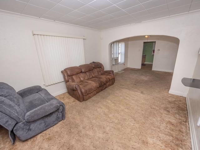 carpeted living room with arched walkways and baseboards