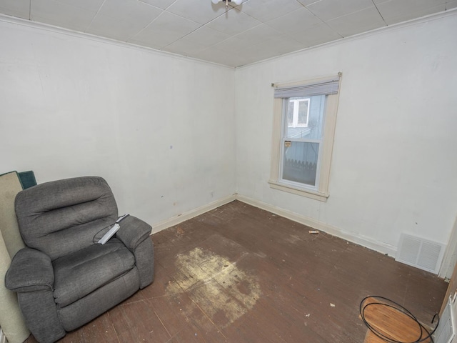 living area with visible vents, baseboards, and wood finished floors