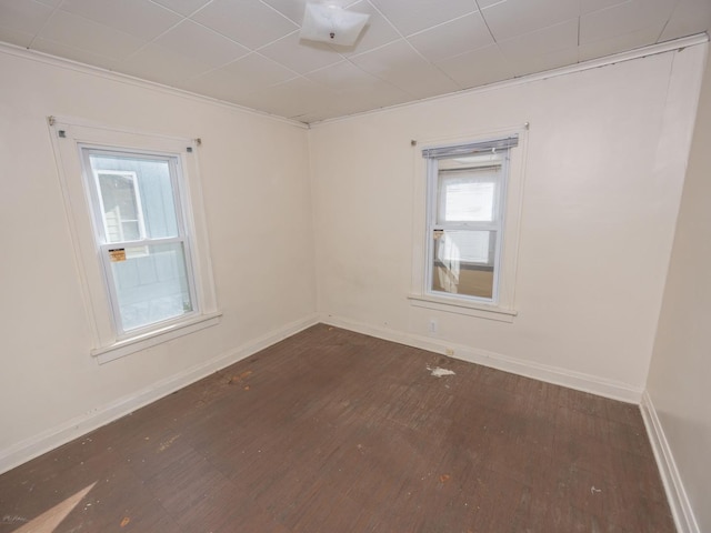 unfurnished room with dark wood-style flooring and baseboards