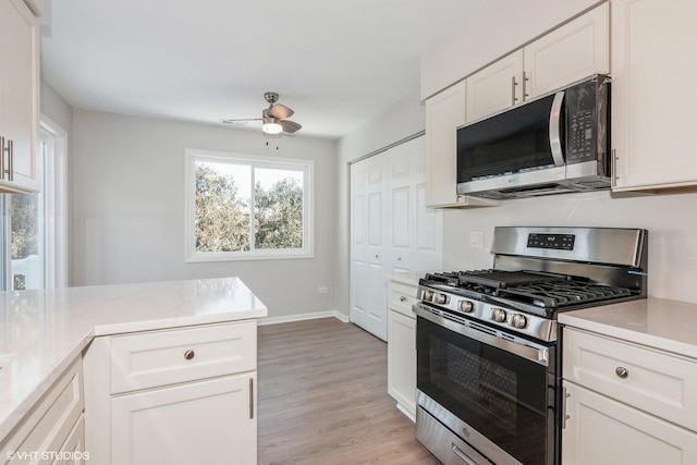 kitchen featuring white cabinetry, light wood-type flooring, ceiling fan, and appliances with stainless steel finishes