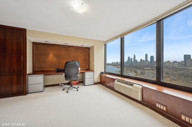 office area with an AC wall unit, a water view, and light colored carpet