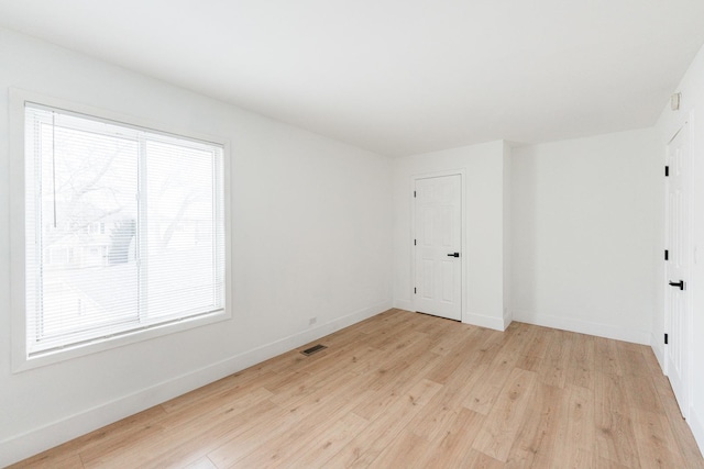 empty room with light hardwood / wood-style flooring