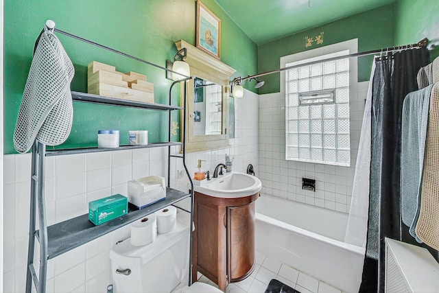 full bathroom featuring tasteful backsplash, tile walls, vanity, shower / bath combo, and tile patterned flooring