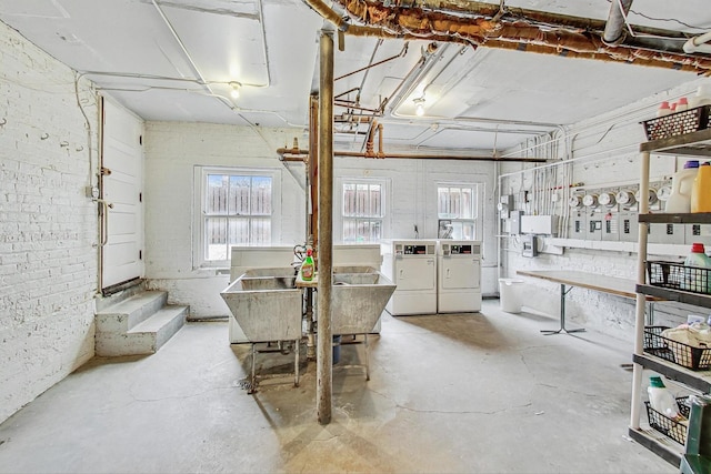 dining area with brick wall, washer and dryer, and concrete floors