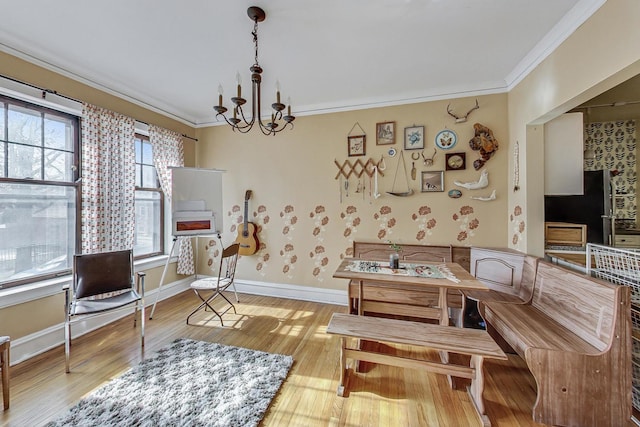 sitting room featuring ornamental molding, a chandelier, and light wood-type flooring