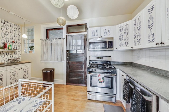 kitchen with wine cooler, hanging light fixtures, light wood-type flooring, appliances with stainless steel finishes, and white cabinets