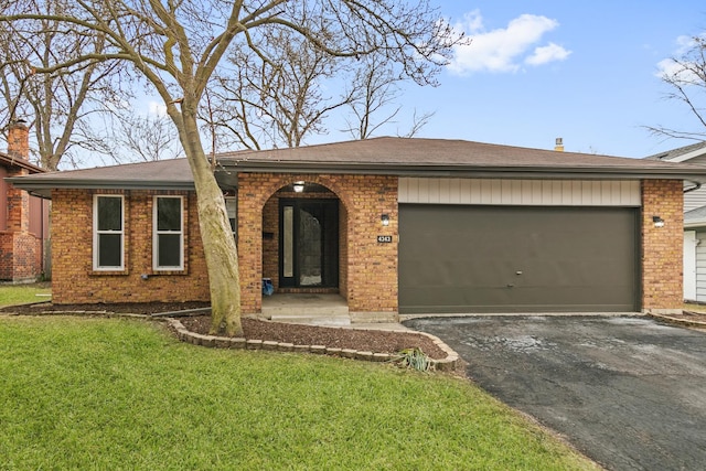 ranch-style house featuring a garage, a front yard, brick siding, and driveway