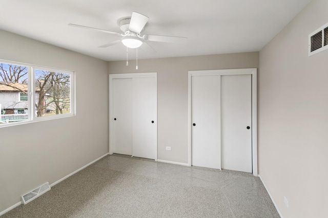 unfurnished bedroom with multiple closets and ceiling fan