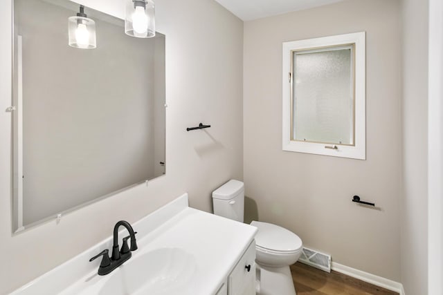 bathroom with hardwood / wood-style flooring, vanity, and toilet