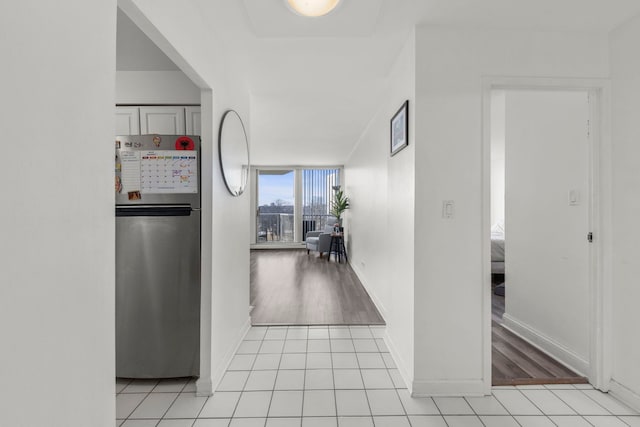 corridor featuring a wall of windows and light tile patterned floors