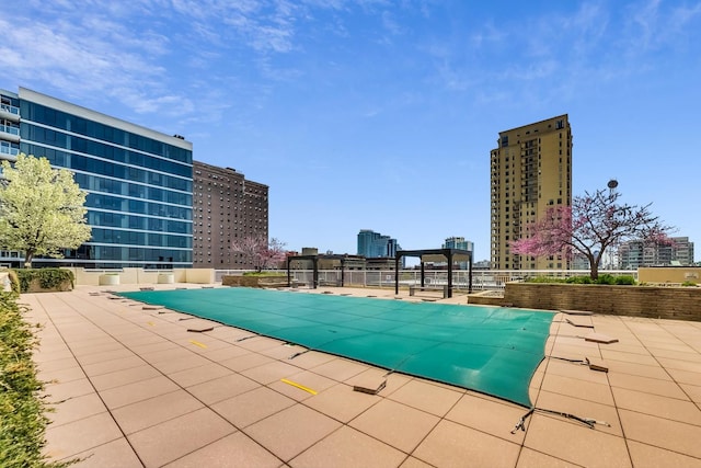 community pool with a patio and a city view