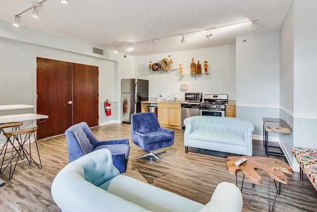 living area with baseboards, visible vents, and light wood finished floors