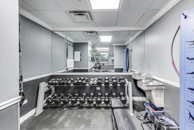 exercise area with ornamental molding, a drop ceiling, and visible vents