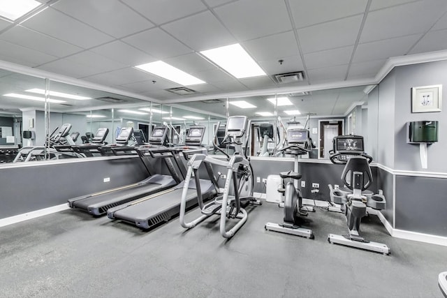 gym featuring a paneled ceiling, visible vents, and baseboards