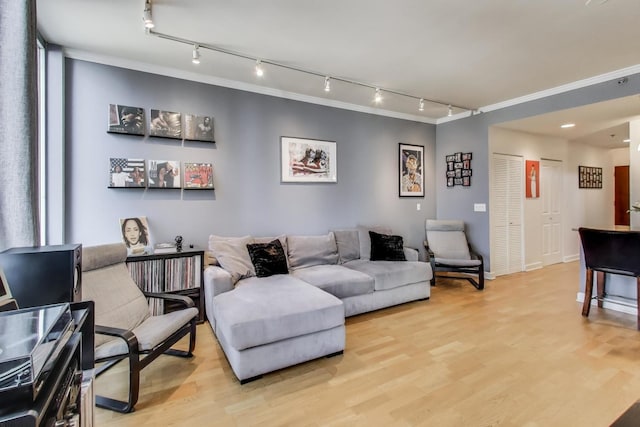 living area with light wood-style flooring and ornamental molding