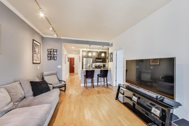 living area with rail lighting, crown molding, visible vents, and light wood finished floors