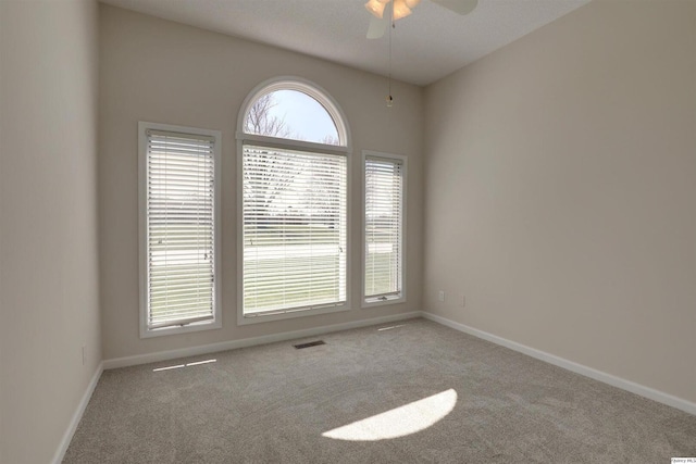 unfurnished room featuring a ceiling fan, carpet, baseboards, and visible vents