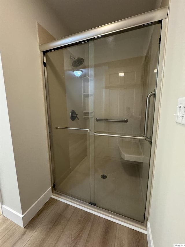 bathroom with wood-type flooring and walk in shower