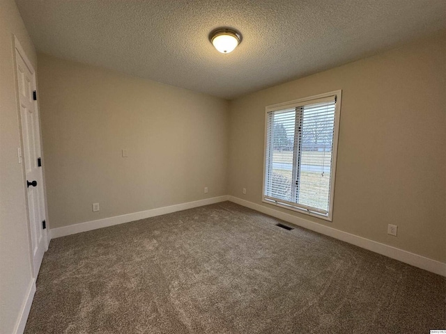 unfurnished room with carpet floors and a textured ceiling